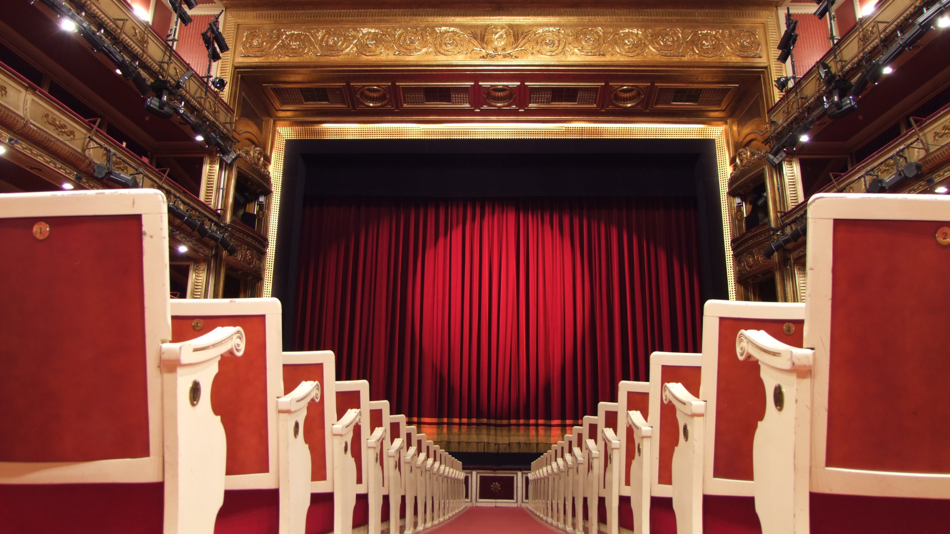 Interior del Teatro de la Zarzuela con el telón rojo cerrado visto desde el patio de butacas.