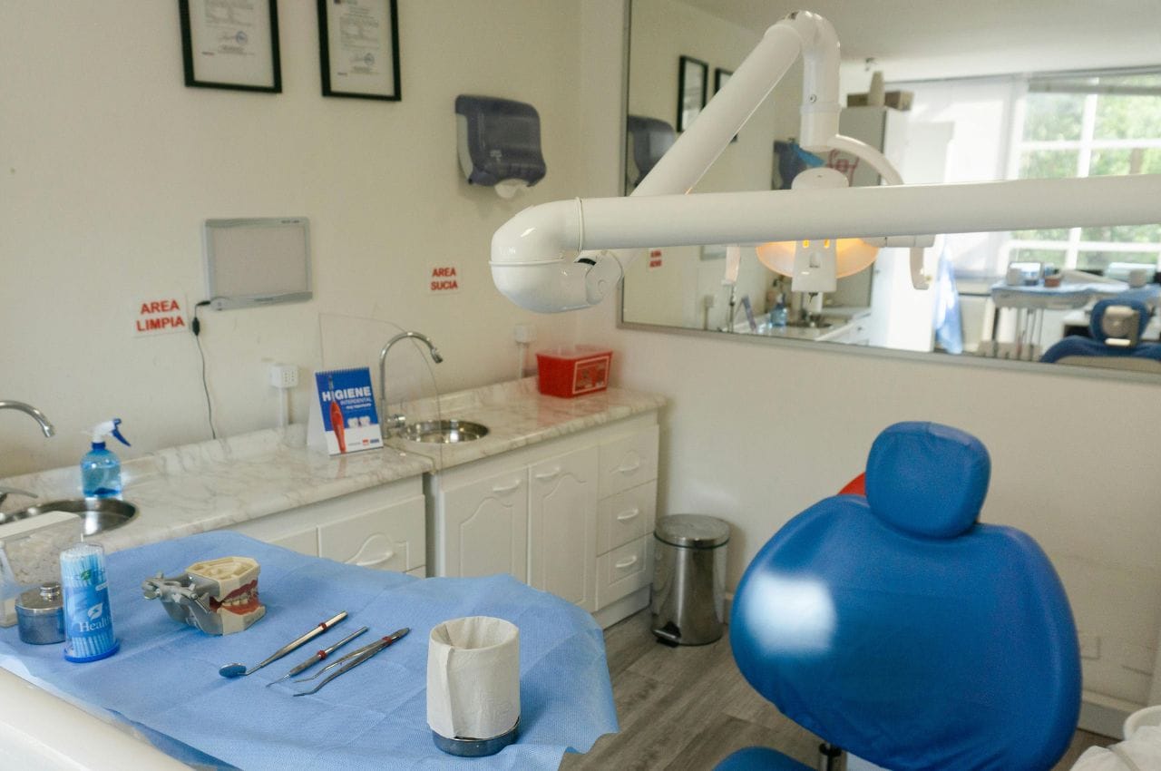 Interior de un consultorio dental con instrumentos médicos y una dentadura postiza sobre la mesa.